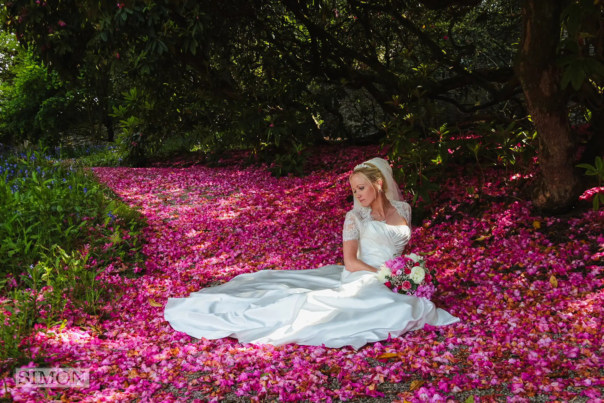 Bride sitting in pink flower petals